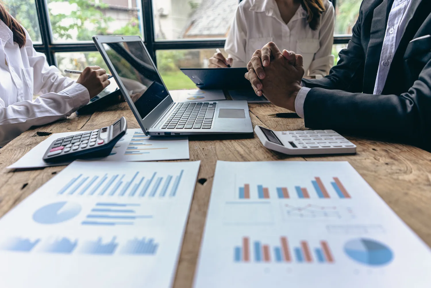 Group of businessmen holding smart pen discussing in group meeting at table in modern office with graph papers and laptop Strategic Planning, Business Collaboration and Brainstormi